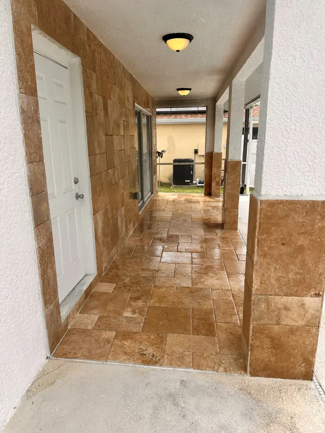 Interior hallway with a travertine floor running through to the back of the house